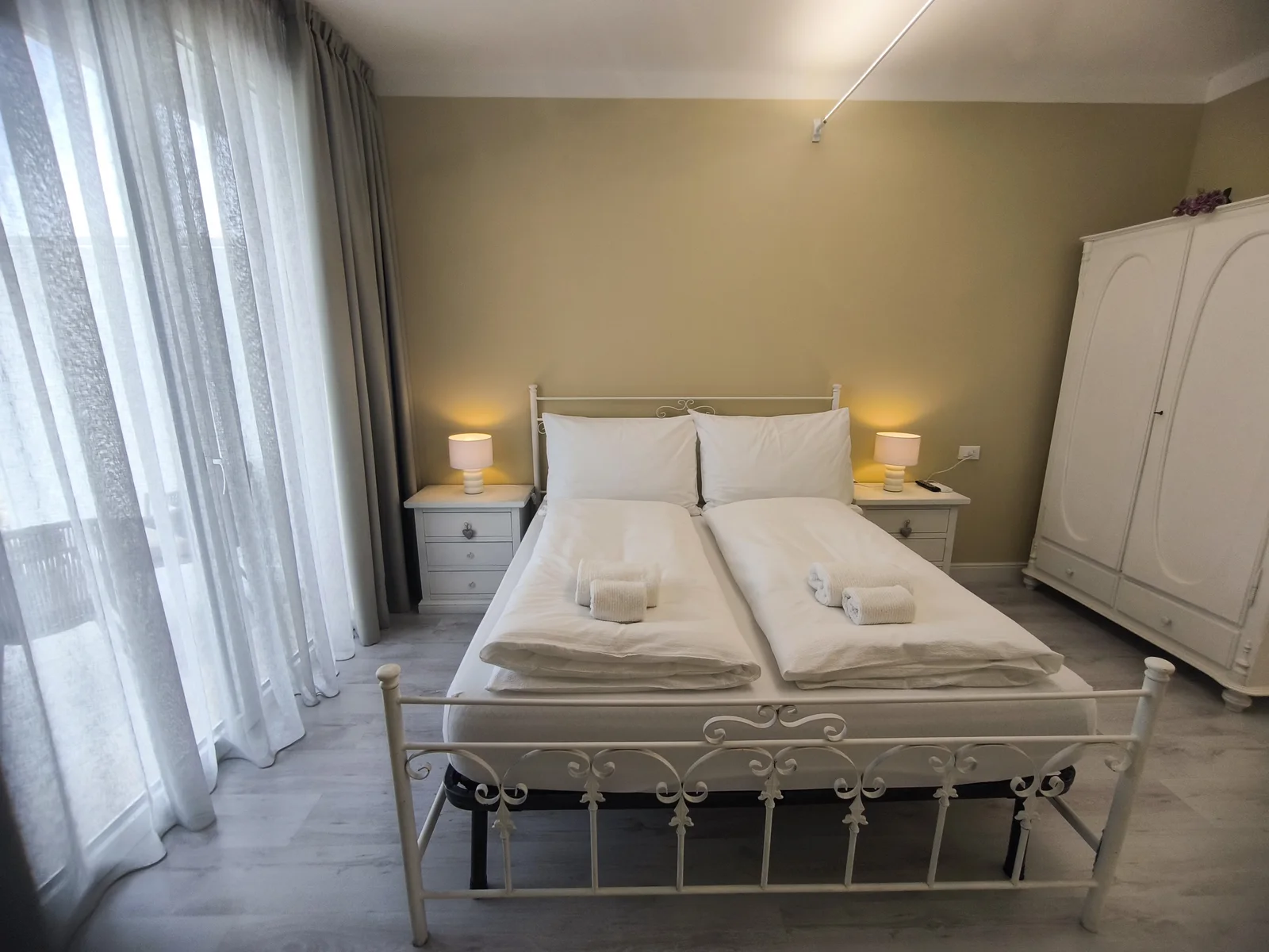 Main double bed, wardrobe and balcony doors in the Dolce Vita quad room