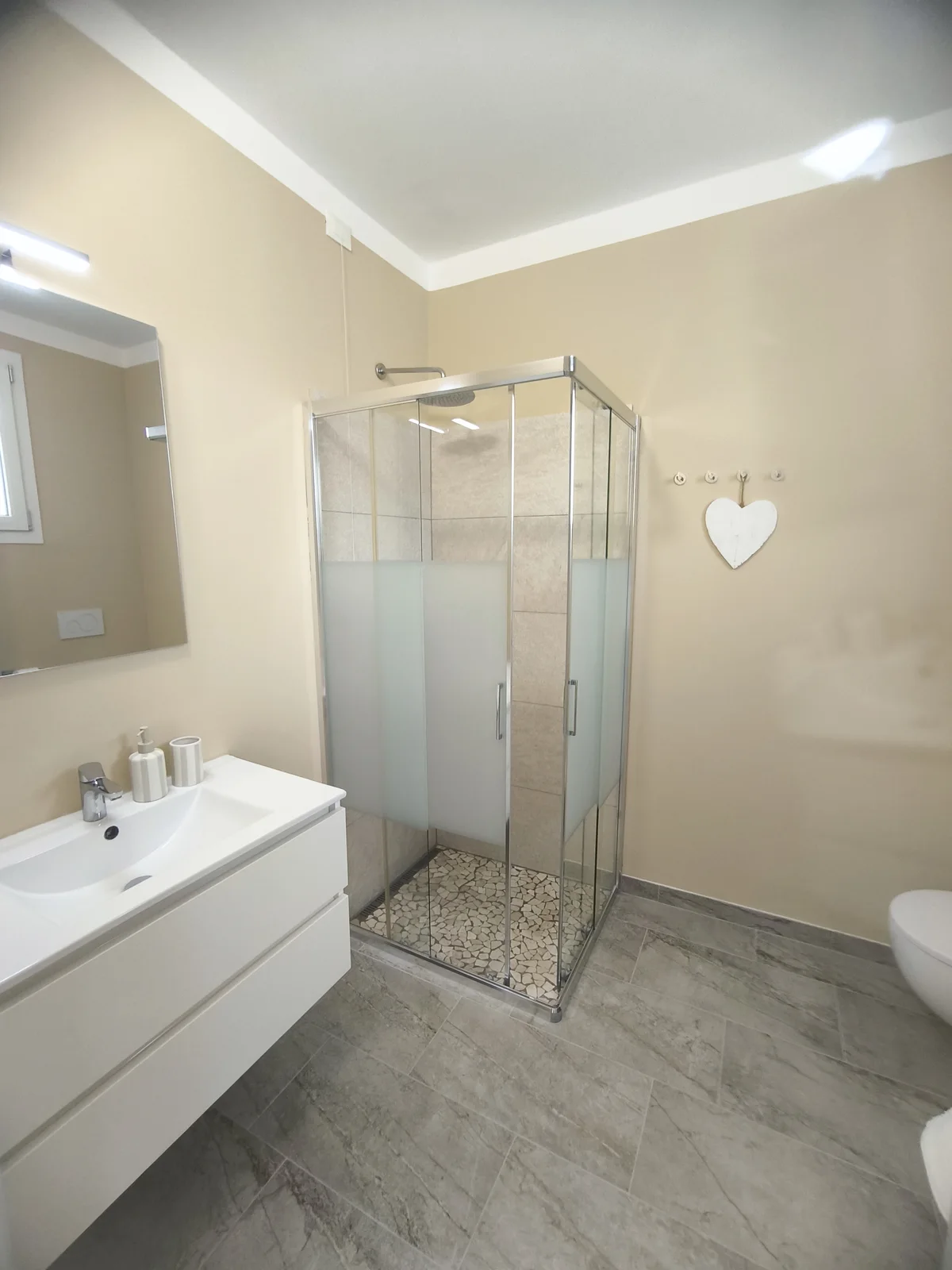 Renovated private bathroom with walk-in shower and vanity in the Dolce Vita room
